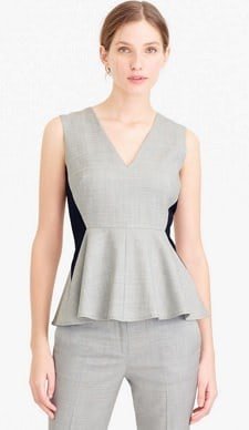 Mulher usa o trabalho de trabalho sem mangas cinza com detalhes coloridos e peplum em um material de adequação