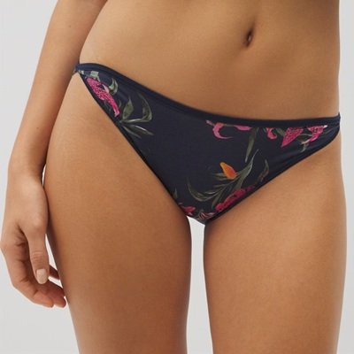 A parte inferior do corpo de uma mulher; Ela está usando roupas íntimas de biquíni em uma estampa floral negra
