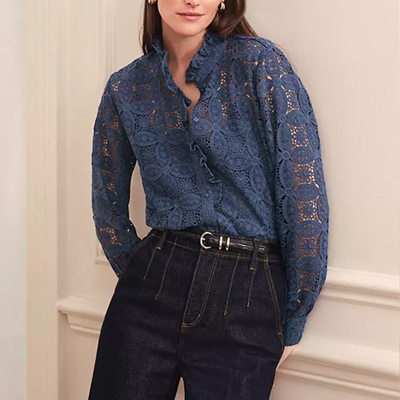 Mulher usa blusa de renda azul escura que é um pouco pura