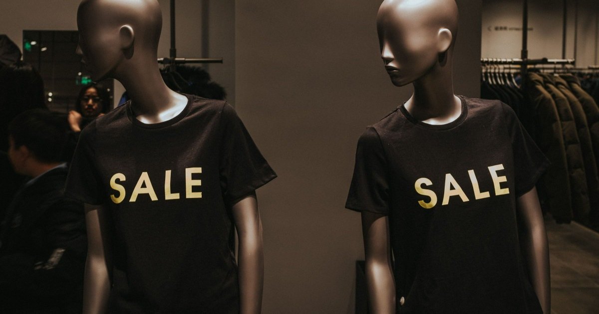 Os manequins da loja usam camisetas que dizem venda