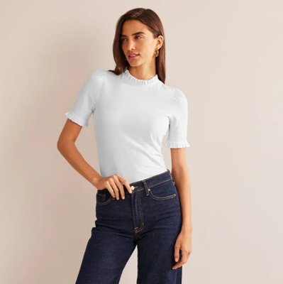 Uma mulher vestindo uma blusa branca e jeans azul escuro