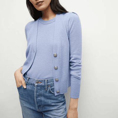 Mulher usa cardigã de cashmere azul pálido com cashmere azul pálido; É um gêmeo