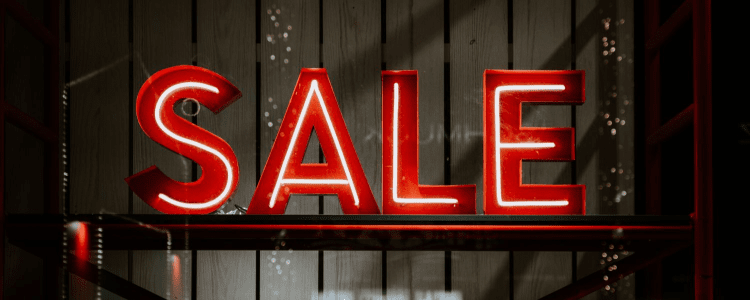 letras neon vermelhas significam VENDA na vitrine de uma loja