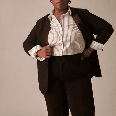 mulher usa paletó preto, calça preta e blusa listrada