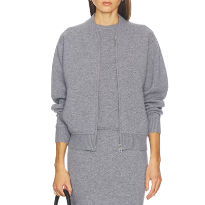 mulher usa jaqueta bomber de malha cinza, regata cinza e saia de malha cinza combinando