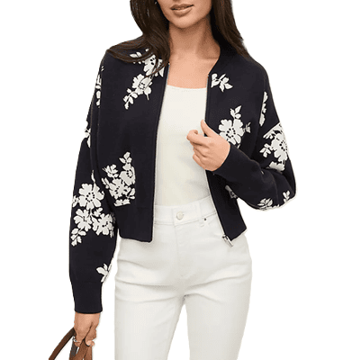 mulher usa coluna colorida com jaqueta bomber; suas calças e blusa são brancas, enquanto sua jaqueta bomber é preta floral