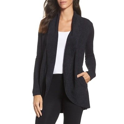 Uma mulher vestindo uma jaqueta preta de trabalho e calça com blusa branca.