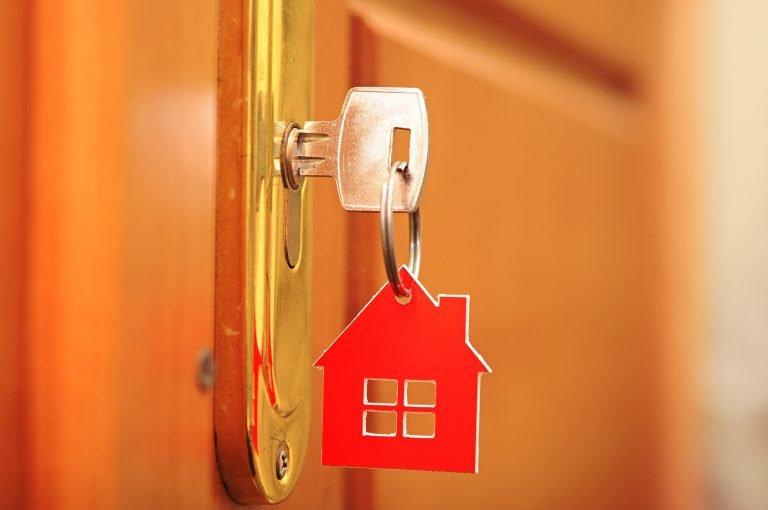 Chave na fechadura da porta - chaveiro em formato de casa