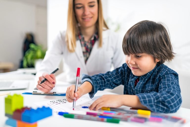 Pedagoga observa uma criança desenhar