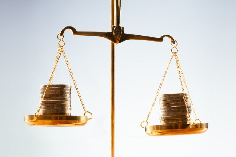 Balança tentando equilibrar moedas dos dois lados
